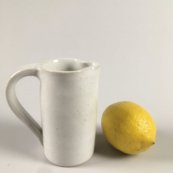 Handmade pottery cream jug in shiny white glaze